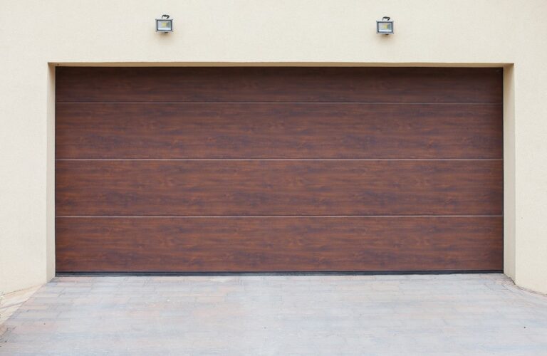Closed brown wooden garage door with horizontal panels on a brick building