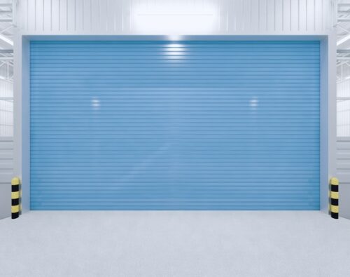 A closed blue industrial roll-up door with yellow and black safety bollards on each side in a clean, well-lit warehouse.