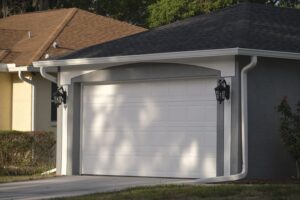 A closed white garage door on a suburban house