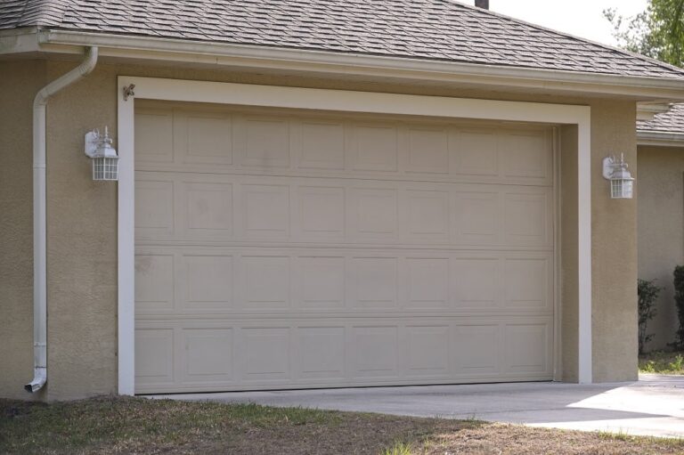 A closed beige garage door on a residential house