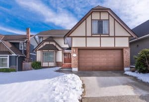 luxury house with garage door during winter
