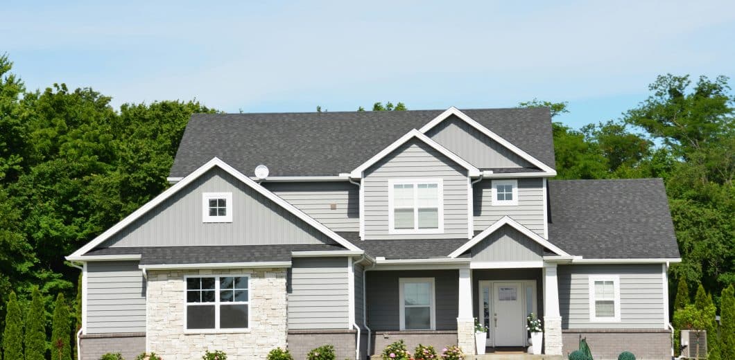 Modern grey house with a green lawn and trees