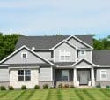 Modern grey house with a green lawn and trees