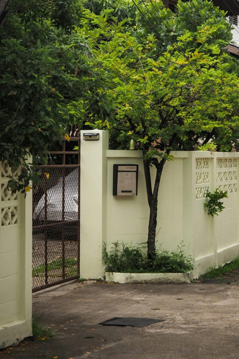 White wall with a metal gate and mailbox