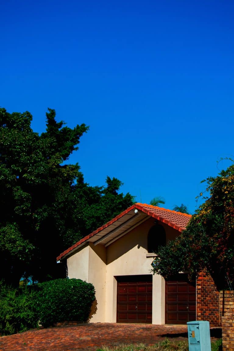 House with red roof and two brown garage doors