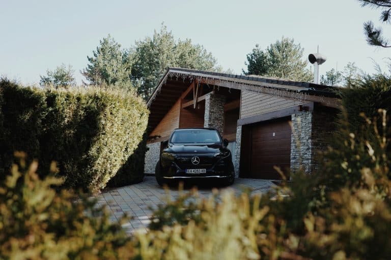 Black car parked in the driveway of a house