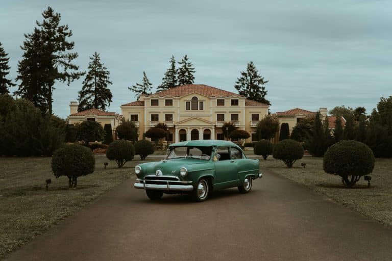 Car parked in front of a large house