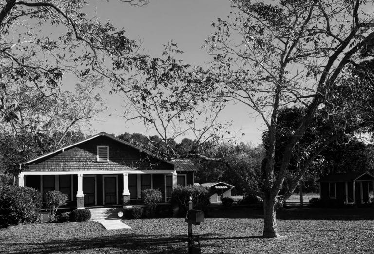 House with a porch and large trees