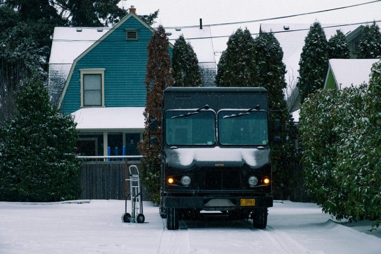 Van parked in front of a brown house