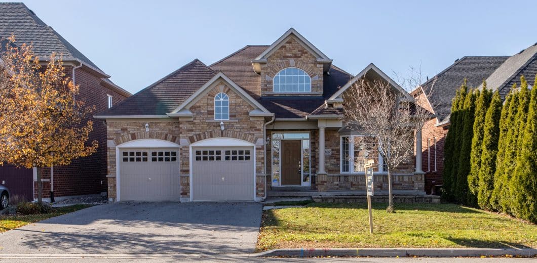 Brown and white house exterior with attached garage in a residential neighborhood