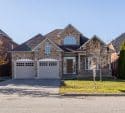 Brown and white house exterior with attached garage in a residential neighborhood