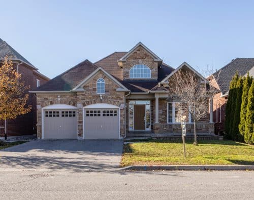 Brown and white house exterior with attached garage in a residential neighborhood