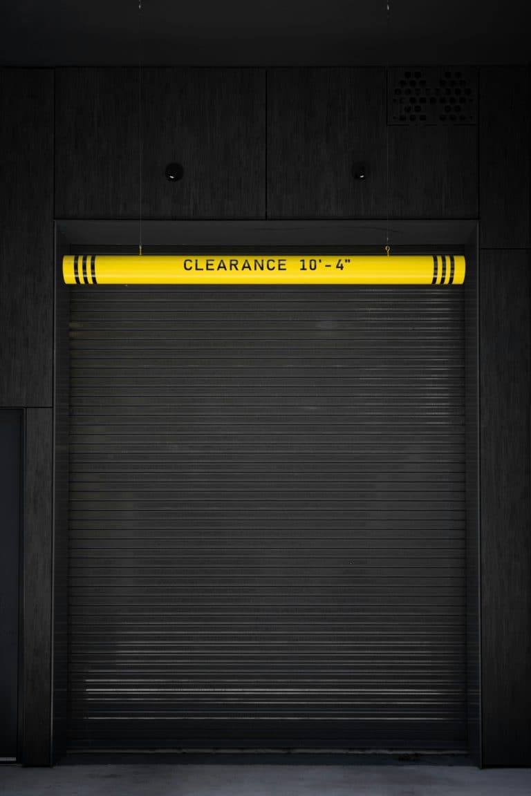 Closed garage door with a caution sign, representing a warning sign homeowners should watch for