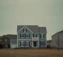 Blue two-story house with black shutters
