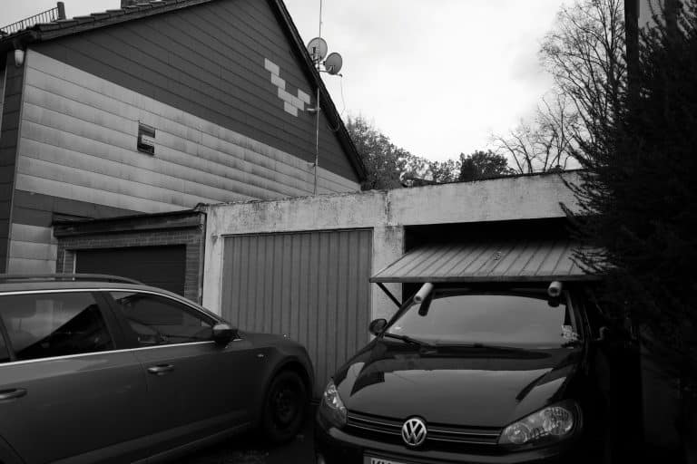 Two cars parked in front of a residential garage