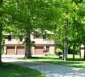 House with three garage doors surrounded by trees