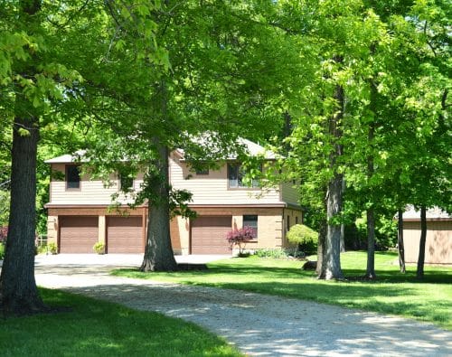 House with three garage doors surrounded by trees