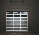 Glass panel garage door on a dark brick garage