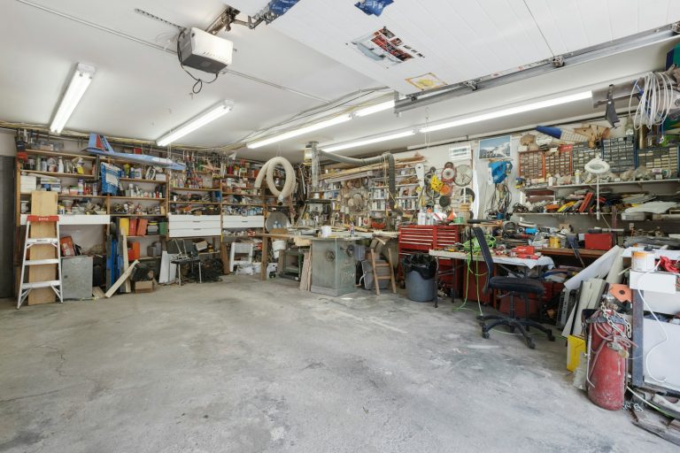 Garage interior with a ceiling mounted opener above stored tools