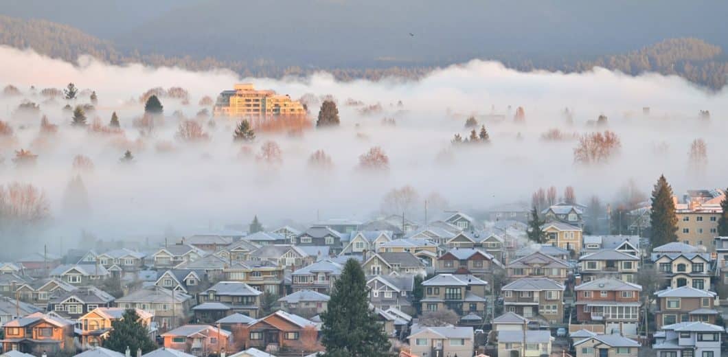 Quiet residential neighborhood under morning fog at sunrise
