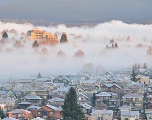 Quiet residential neighborhood under morning fog at sunrise