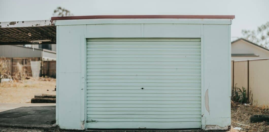Older mint green garage door showing years of seasonal wear