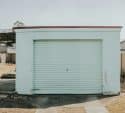 Older mint green garage door showing years of seasonal wear