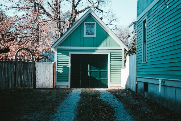 Older detached garage with a dark door in late fall