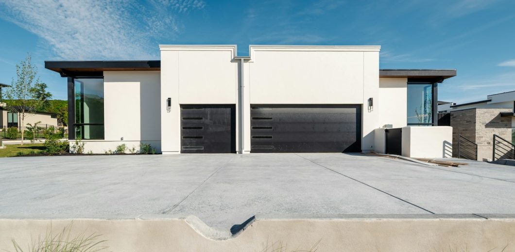 Modern white homes with wide black garage doors