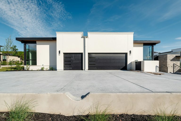 Modern white homes with wide black garage doors