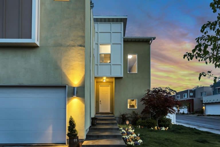 Modern home with a white garage door at dusk