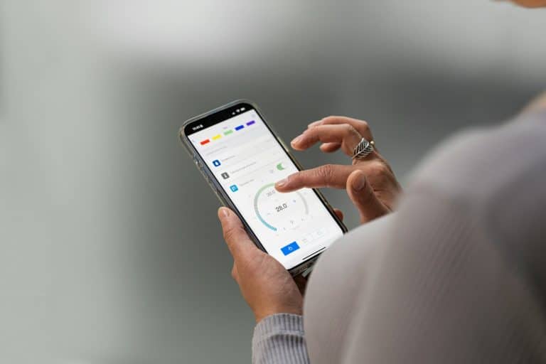 Hands using a smart home control app on a phone