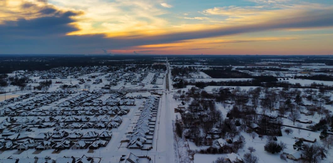 Snow covered neighborhood of homes at sunset