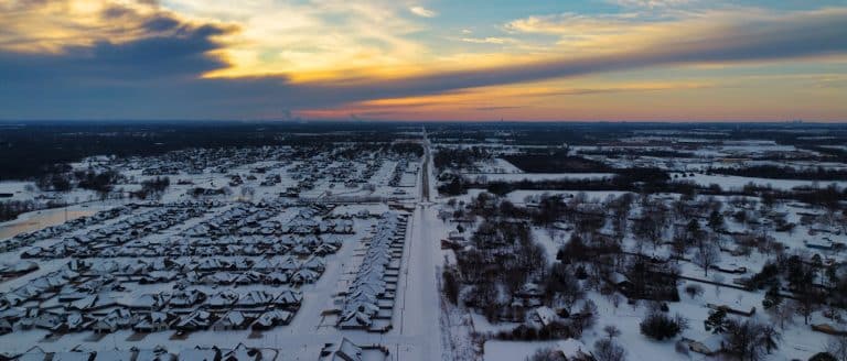 Snow covered neighborhood of homes at sunset