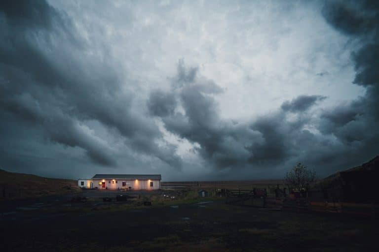 Storm clouds building over a lit rural property