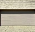 Wide sectional garage door on a shingle sided garage