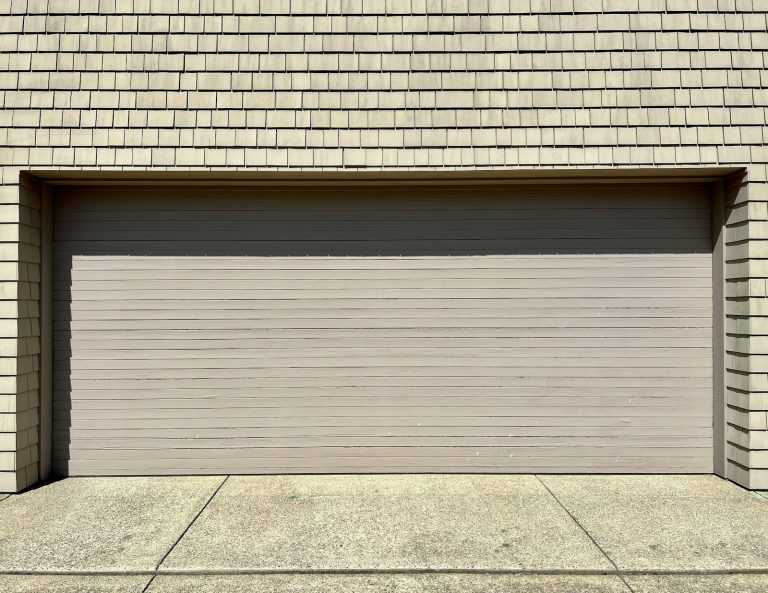 Wide sectional garage door on a shingle sided garage